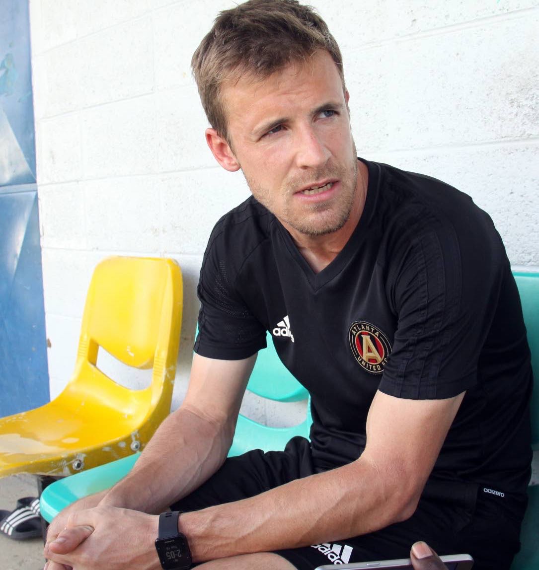 Atlanta United coach Matthew Lawrey observes a session at a camp held in collaboration with Queen’s Park Academy at CIC Ground, St Clair, yesterday.