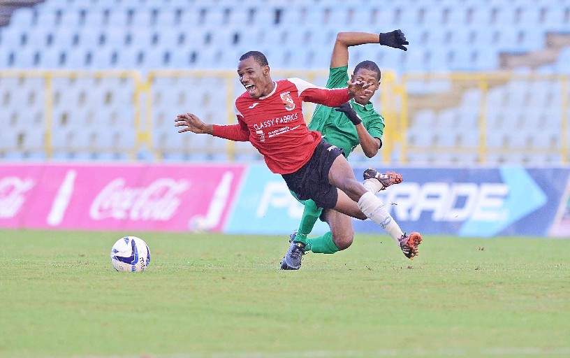 UPENDED: St Anthony’s College’s Shakeem Patrick, left, is fouled by Carapichaima East Secondary’s Colin Wheeler during the first half of their Coca-Cola InterCol semi-final match at the Hasely Crawford Stadium, yesterday. St Anthony’s won 2-0 to advance to next Monday’s final. —Photo: Ishmael Salandy