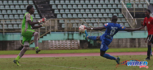 Photo: Naparima College midfielder Rushawn Murphy (right) prods past Pleasantville Secondary goalkeeper Raheem Lee during Coca Cola Intercol South Zone quarterfinal action at the Mannie Ramjohn Stadium on 10 November 2017. (Courtesy Sean Morrison/Wired868)