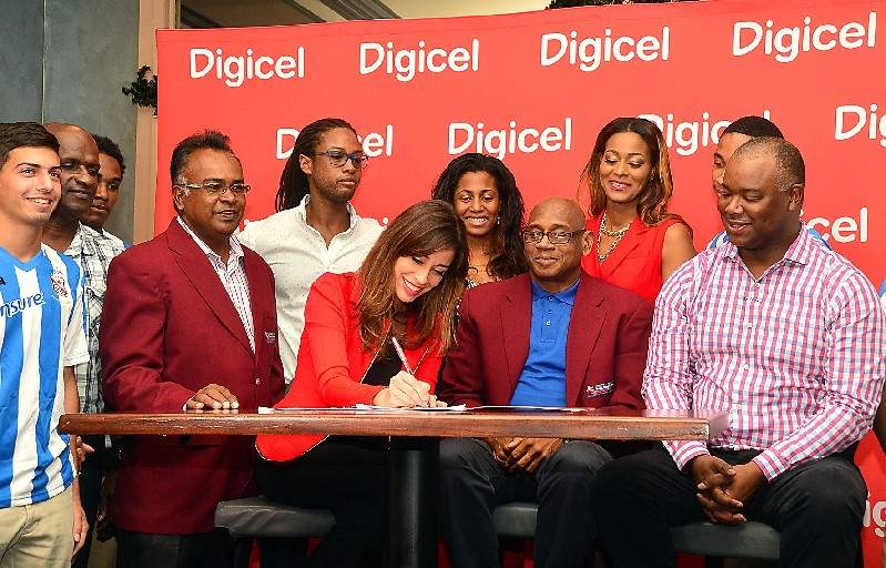 SEALING THE DEAL: Sacha Thompson CEO for Digicel Trinidad and Tobago third from left, signs the new five-year deal with the Secondary Schools Football League, (SSFL) which includes an agreement to televise the matches from the start of next season. Seated next to her is Anthony Creed, centre, president of the SSFL, and Oliver McIntosh, far right, CEO of Digicel Sportsmax. —Photo: Kerwin Pierre