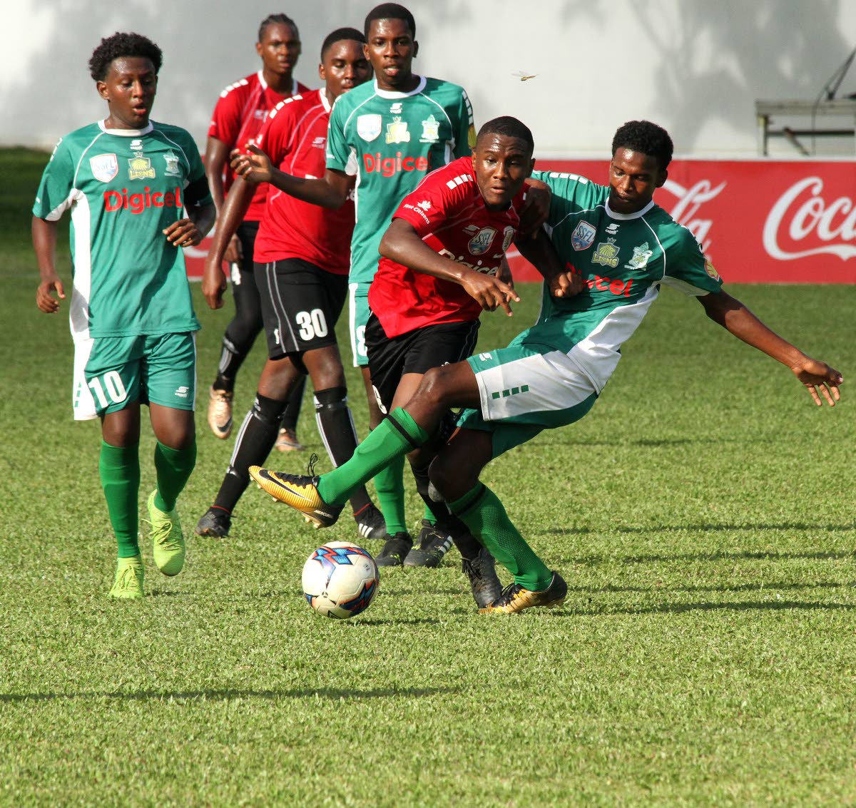 St Anthony's Romario Burke, second from right, is tackled as he makes a run against Trinity College in the Coca Cola North Zone Intercol final yesterday at CIC Ground, St Clair.