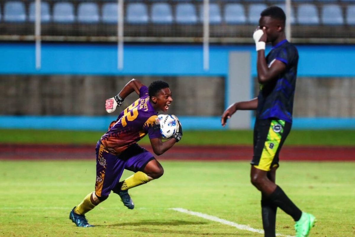 St Benedict's College goalkeeper Thane Devenish, left, runs off with the ball after making his second save of the penalty shootout against Signal Hill Secondary during the SSFL Boys Intercol semifinal at the Ato Boldon Stadium on Friday, November 29th 2024 in Balmain, Couva. PHOTO BY Daniel Prentice