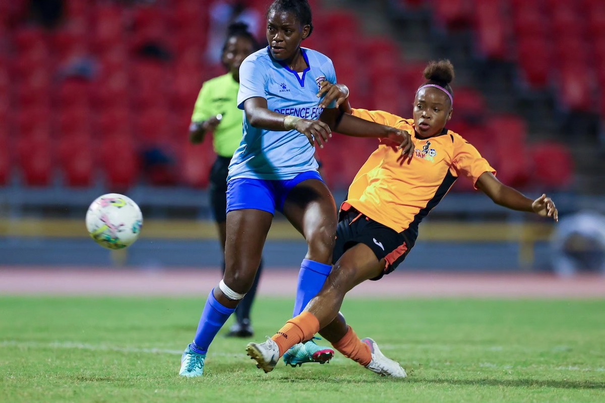 Club Sando’s Nikita Gosine, right, shoots and scores while under pressure from Defence Force Akilah Gomez during the Defence Force Women Warriors Wellness football tournament final match at the Hasely Crawford Stadium in Mucurapo on July 19, 2024. Club Sando won 2-1.