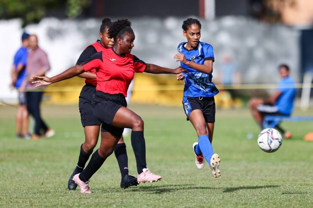 Holy Name Convent attacker Chaya Vincent, right, takes a shot while under pressure from Bishop Anstey High defenders during a Secondary School Football League girls north zone championship match at the St Mary's College grounds, St Clair on Thursday, September 21st 2023. - Photo by Daniel Prentice