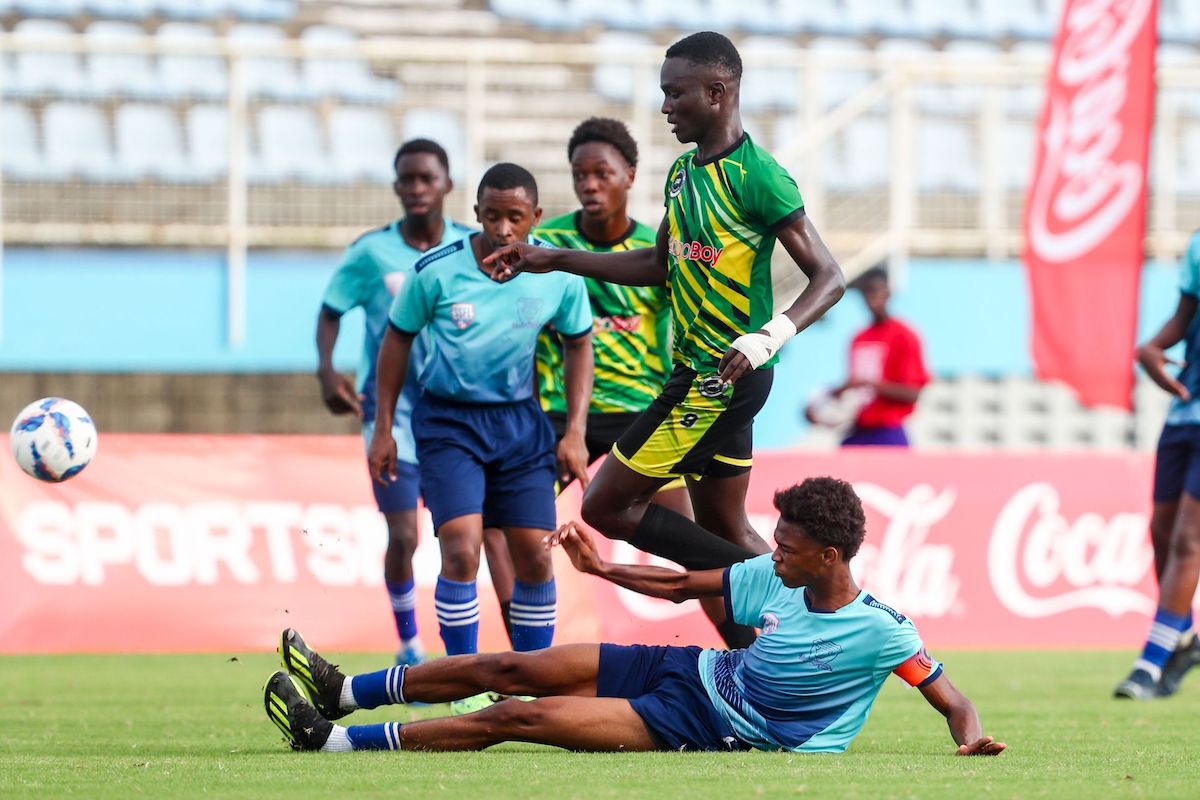 Miracle Ministries' defender and captain Terriq Thomas (on the ground) clears the ball from Signal Hill Secondary Kyle James during the SSFL Boys Big 5 semi final at the Ato Boldon Stadium in Balmain, Couva on Tuesday, November 26th 2024. PHOTO BY Daniel Prentice