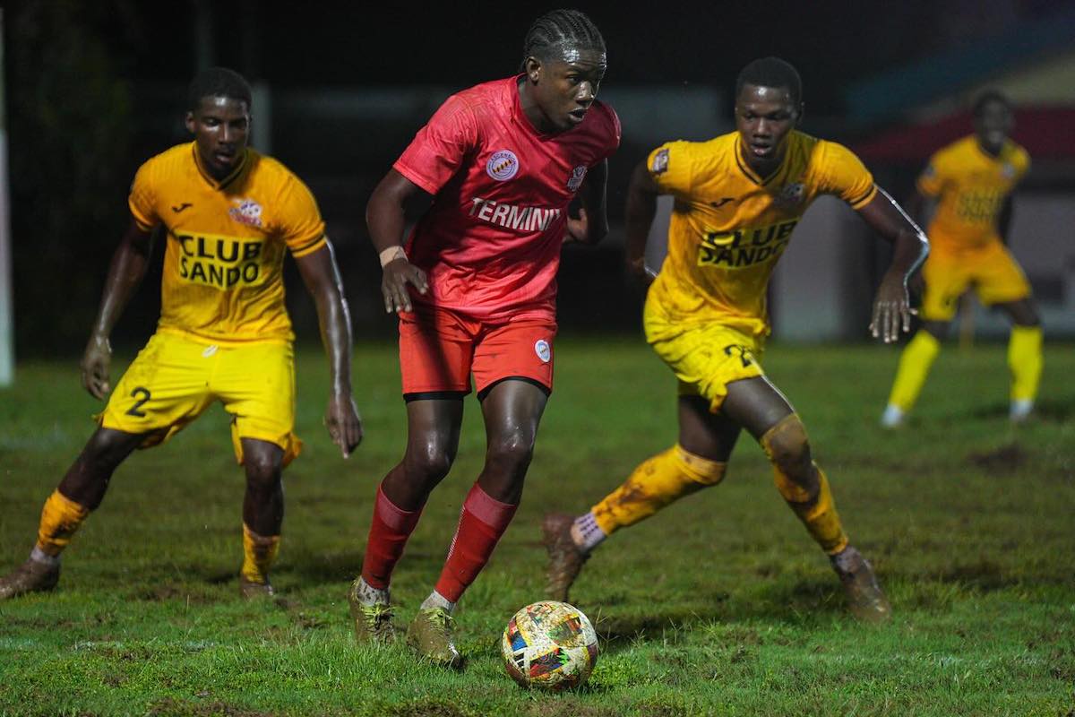 La Horquetta Rangers' Malachi Celestine (center) is marked by two Club Sando players during a TTPFL game at La Horquetta Recreation Ground on Friday, December 13th 2024.