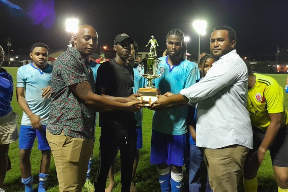 Then-Eastern Football Association (EFA) general secretary Gregory McBurnie (right) and former Fifa assistant referee Kevin Lewis (left) present the 2024 EFA trophy to Malabar Youngstars in October 2024.