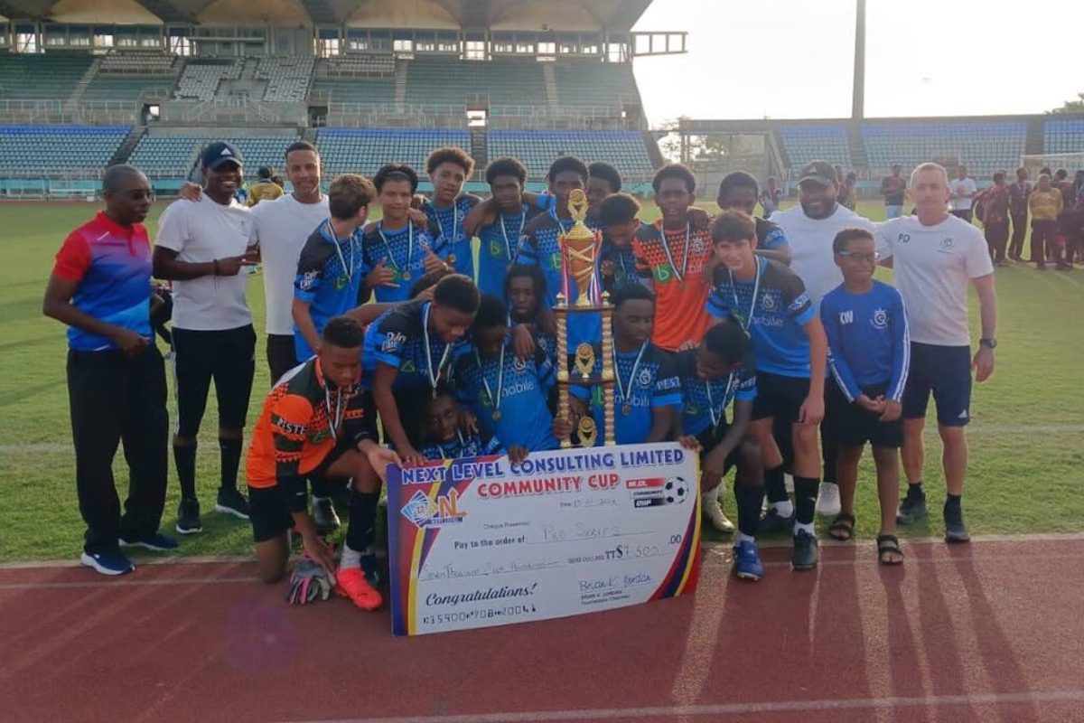 Pro Series' players and staff celebrate with their winners' cheque and trophy after copping the 2024 Next Level Consulting Ltd Under-15 Community Cup title at the Manny Ramjohn Stadium, Marabella on July 13, 2024.