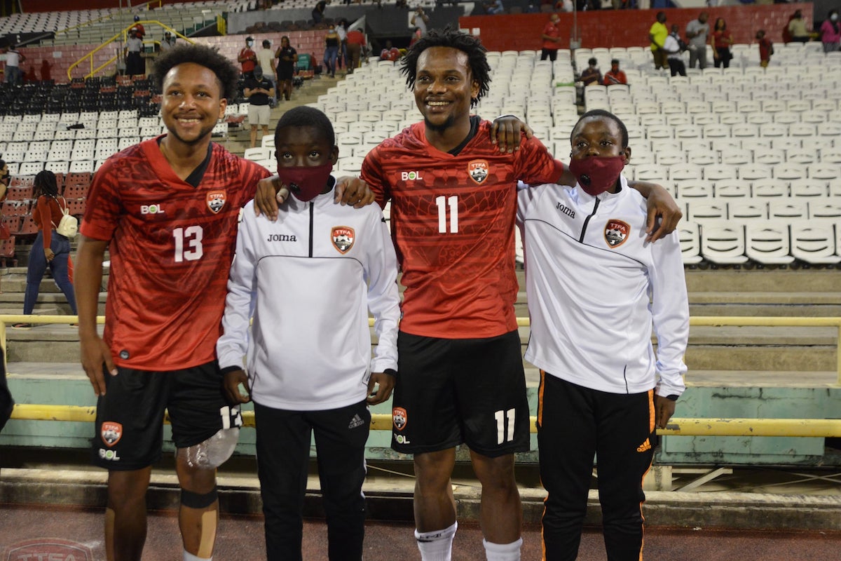 Brothers Levi (#11) and Judah Garcia (#13) pose with two ball boys after a Courts Classic game against Barbados at Hasely Crawford Stadium, Port of Spain on March 25th 2022.